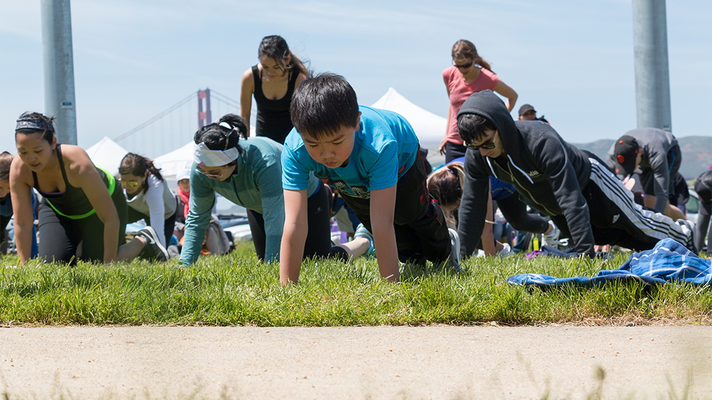 Kid and others doing push ups