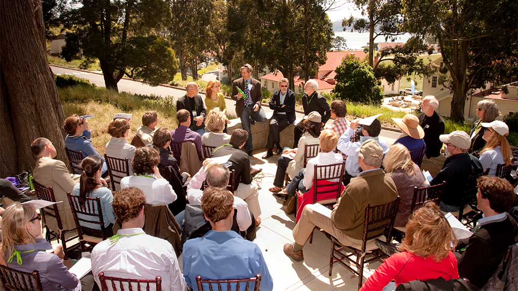 People sitting outside for a training. 